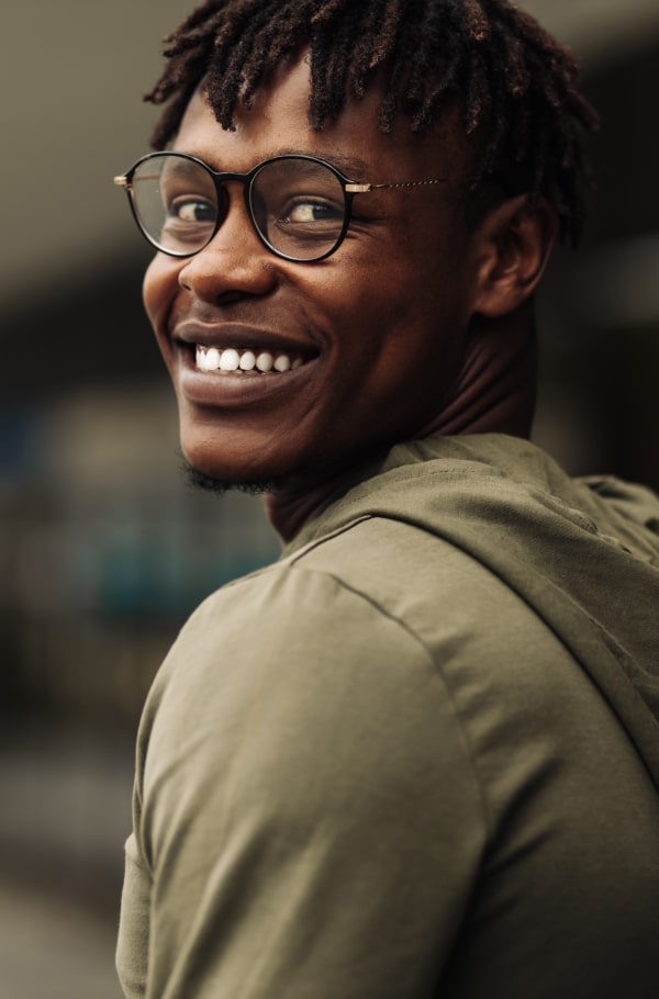 Improve Your Smile, Bite, and Confidence. A boy is happily smiling on the street