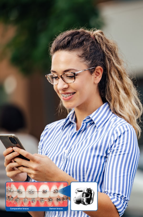 A Faster, More Comfortable Way to Straighten Your Teeth. A woman is smiling and holding her phone